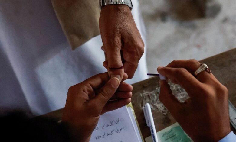 a voter gets an ink mark on his thumb after casting his vote during the general election in karachi photo reuters