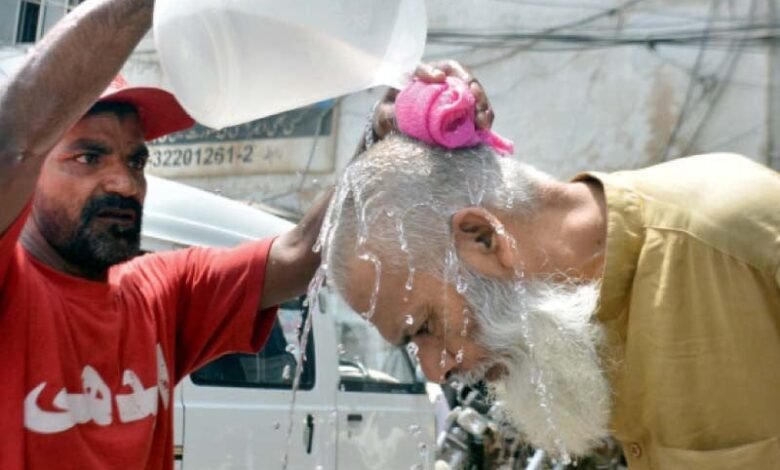 an edhi volunteer provides an elderly passerby relief from the heat near merewether tower in karachi photo jalal qureshi express