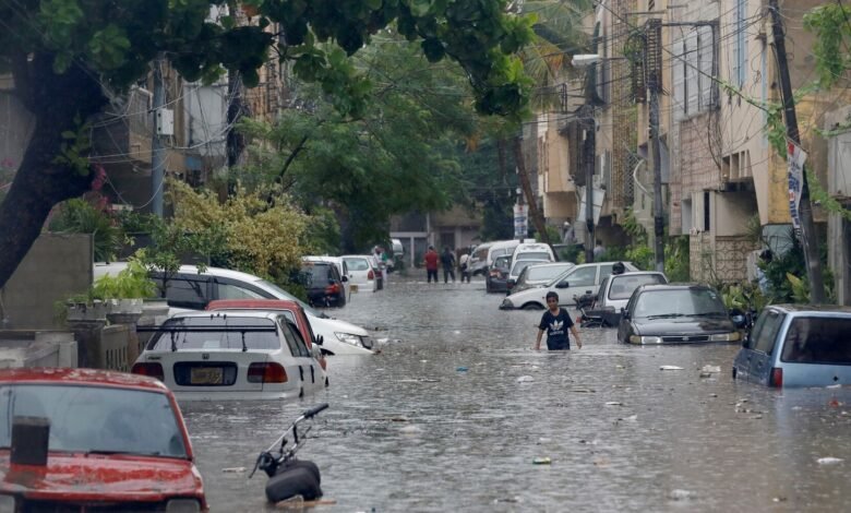 a boy wades through a flooded street with submerged vehicles during the monsoon rain as the outbreak of the coronavirus disease covid 19 continues in karachi pakistan august 25 2020 reuters akhtar soomro